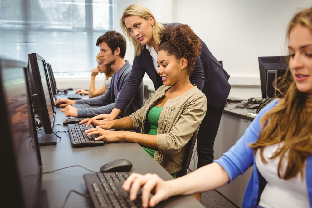 Attractive teacher helping her student in computer class at the university-1